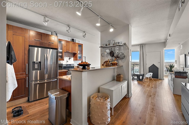 432 S Washington Ave Unit 1402, Royal Oak, MI 48067 - kitchen with stainless steel appliances, hardwood / wood-style flooring, a peninsula, brown cabinetry, and open shelves