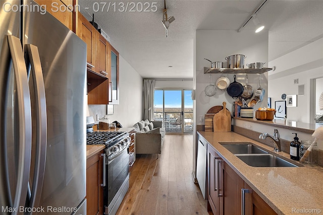 432 S Washington Ave Unit 1402, Royal Oak, MI 48067 - kitchen with stainless steel appliances, brown cabinets, light wood-style floors, open floor plan, and light stone countertops