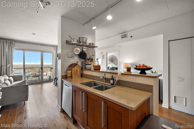 432 S Washington Ave Unit 1402, Royal Oak, MI 48067 - kitchen with open floor plan, dishwashing machine, brown cabinets, light wood-style floors, and rail lighting