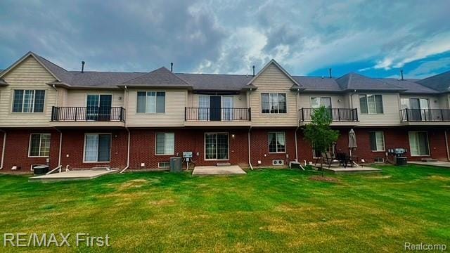 45903 Dutton Dr, Shelby Twp, MI 48044 - rear view of house featuring a yard, brick siding, and a patio area
