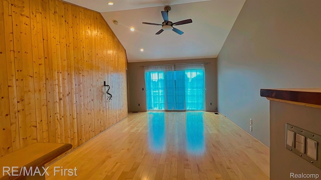 45903 Dutton Dr, Shelby Twp, MI 48044 - unfurnished living room with vaulted ceiling, wood walls, ceiling fan, and wood finished floors