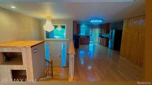 45903 Dutton Dr, Shelby Twp, MI 48044 - kitchen featuring freestanding refrigerator, a chandelier, wood finished floors, butcher block countertops, and glass insert cabinets