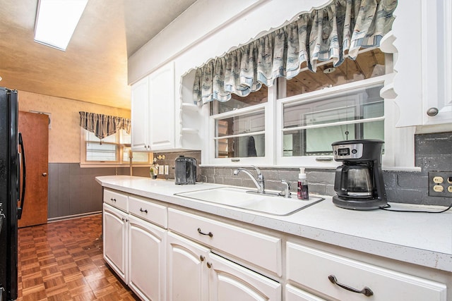 2736 Cascade Rd SE, Grand Rapids, MI 49506 - kitchen with freestanding refrigerator, white cabinets, light countertops, wainscoting, and tasteful backsplash