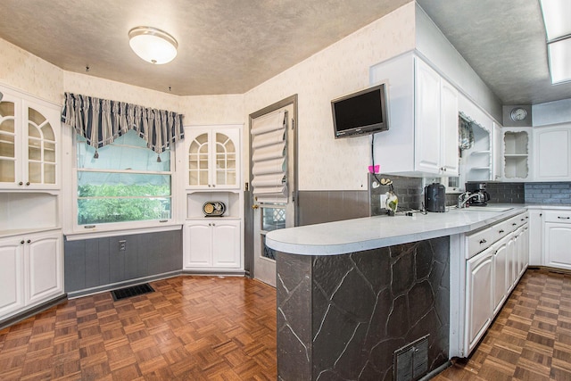 2736 Cascade Rd SE, Grand Rapids, MI 49506 - kitchen with white cabinets, glass insert cabinets, open shelves, light countertops, and a peninsula