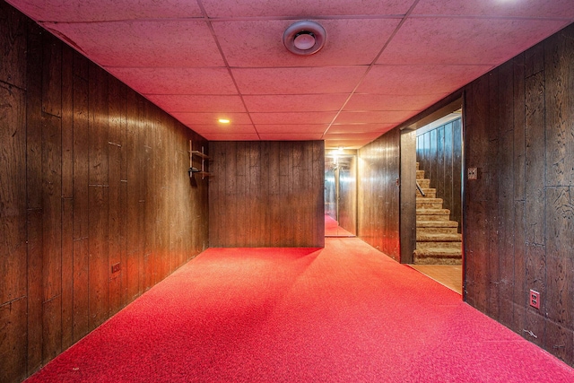 2736 Cascade Rd SE, Grand Rapids, MI 49506 - hallway with wood walls, carpet floors, stairs, and a paneled ceiling