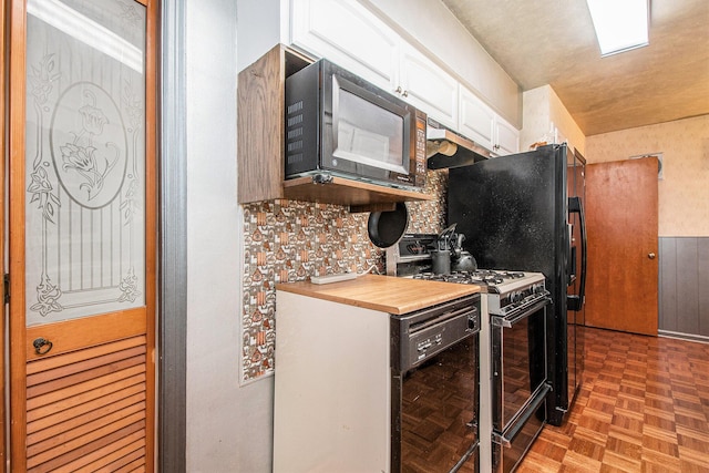 2736 Cascade Rd SE, Grand Rapids, MI 49506 - kitchen featuring black appliances, white cabinets, under cabinet range hood, and wood counters