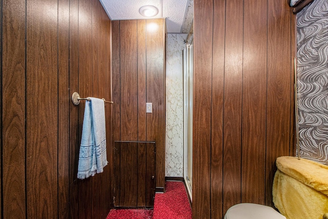 2736 Cascade Rd SE, Grand Rapids, MI 49506 - bathroom featuring a shower with door, a textured ceiling, wallpapered walls, and wooden walls