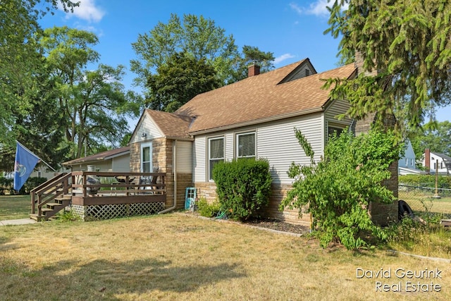 730 S 160th Ave, Holland, MI 49423 - view of side of home with a deck, a chimney, a shingled roof, and stone siding