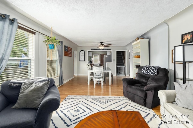 730 S 160th Ave, Holland, MI 49423 - living area with wood finished floors, stairway, ceiling fan, and a textured ceiling