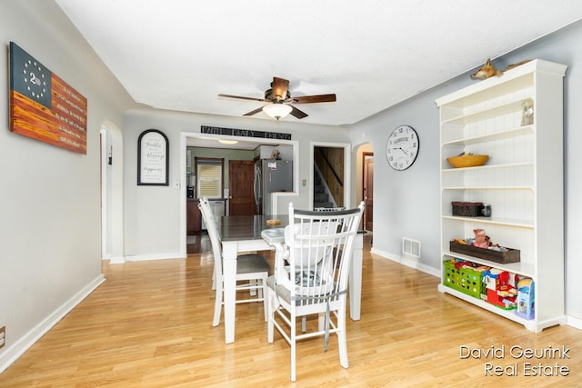 730 S 160th Ave, Holland, MI 49423 - dining room featuring arched walkways, stairs, light wood finished floors, and a ceiling fan