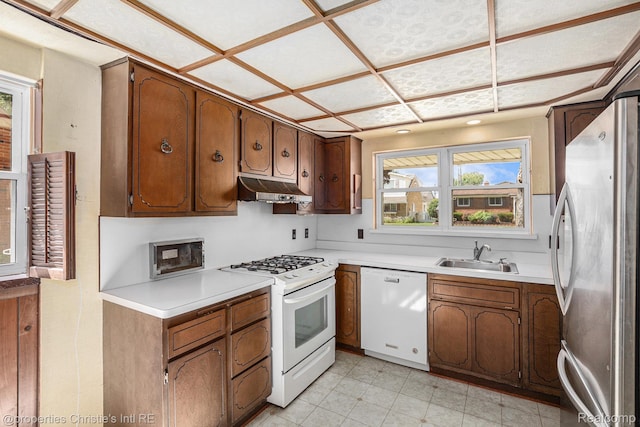 1014 Key W Dr, Clawson, MI 48017 - kitchen featuring white appliances, under cabinet range hood, light countertops, and brown cabinets