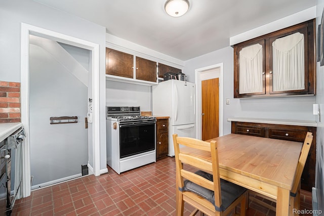 20874 Woodmont St, Harper Woods, MI 48225 - kitchen featuring white appliances, brick patterned flooring, light countertops, and dark brown cabinetry