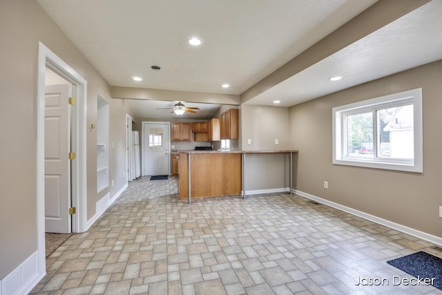 1440 College Ave NE, Grand Rapids, MI 49505 - kitchen with brown cabinetry, recessed lighting, a peninsula, ceiling fan, and light countertops
