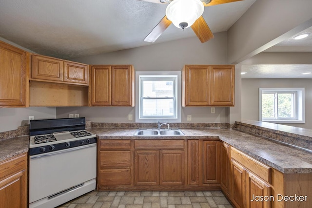 1440 College Ave NE, Grand Rapids, MI 49505 - kitchen with white gas stove, lofted ceiling, a peninsula, dark countertops, and ceiling fan