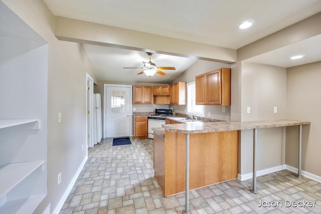 1440 College Ave NE, Grand Rapids, MI 49505 - kitchen featuring white appliances, a peninsula, light countertops, a ceiling fan, and lofted ceiling