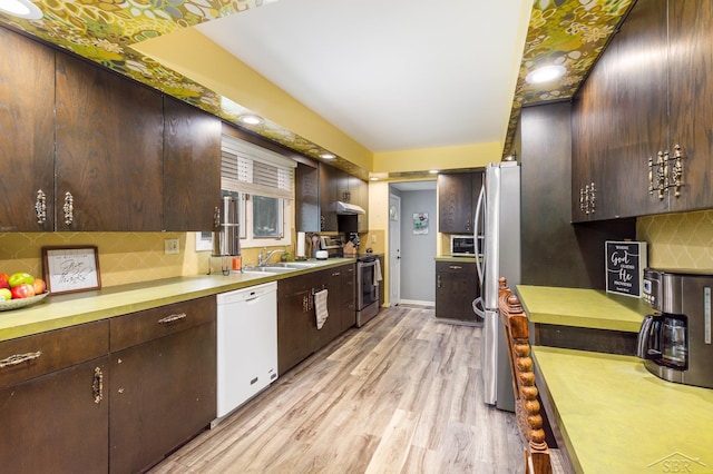 859 Foxboro Rd, Saginaw, MI 48638 - kitchen with appliances with stainless steel finishes, backsplash, dark brown cabinetry, and light wood finished floors