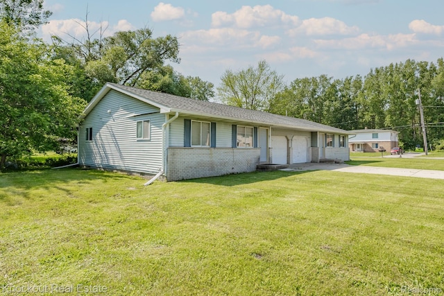 3782 Egan St, Saginaw, MI 48601 - ranch-style home featuring a garage, concrete driveway, a front lawn, and brick siding
