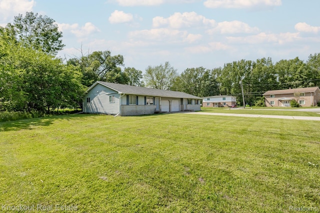 3782 Egan St, Saginaw, MI 48601 - ranch-style home featuring driveway, a front yard, view of wooded area, and a garage