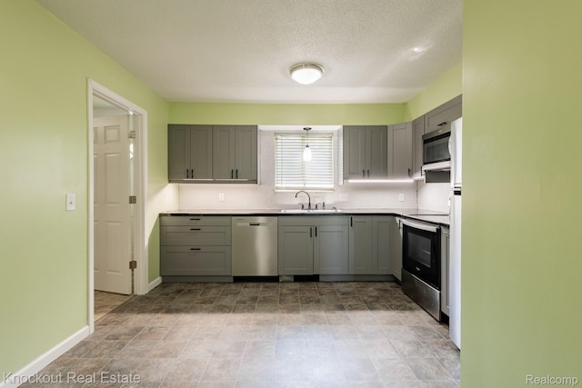 3782 Egan St, Saginaw, MI 48601 - kitchen featuring appliances with stainless steel finishes, gray cabinets, tasteful backsplash, a textured ceiling, and light countertops