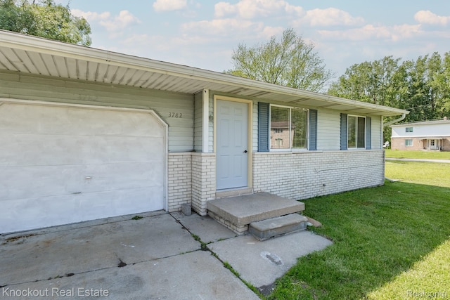 3782 Egan St, Saginaw, MI 48601 - view of front of home with a front lawn, driveway, brick siding, and a garage