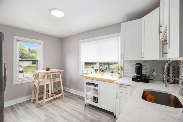1018 S Stephenson Hwy, Royal Oak, MI 48067 - kitchen with decorative backsplash, white cabinetry, and light wood-style flooring