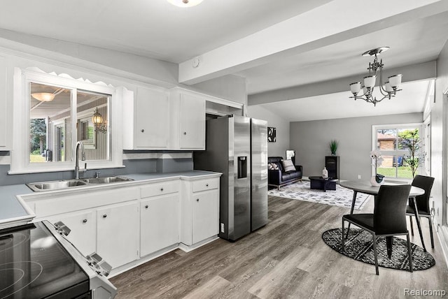 3818 Wisner St, Flint, MI 48504 - kitchen featuring stainless steel fridge, electric range oven, white cabinetry, dark wood-type flooring, and a chandelier