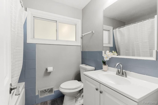 3818 Wisner St, Flint, MI 48504 - bathroom featuring tile walls, vanity, and curtained shower