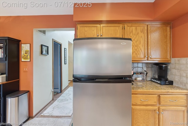 2129 Camelot Dr, Troy, MI 48083 - kitchen with freestanding refrigerator, decorative backsplash, brown cabinetry, and tile counters