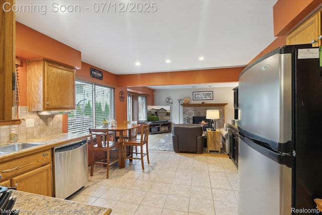 2129 Camelot Dr, Troy, MI 48083 - kitchen with stainless steel appliances, light tile patterned floors, a fireplace, recessed lighting, and tasteful backsplash