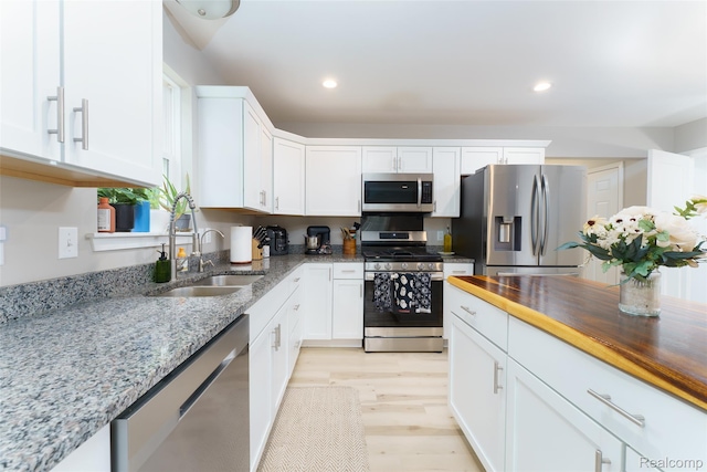 11879 Secluded Ridge Dr, Byron, MI 48418 - kitchen with appliances with stainless steel finishes, white cabinets, light wood-type flooring, light stone countertops, and recessed lighting