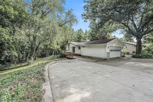 4649 Northview Ave NE, Grand Rapids, MI 49525 - view of property exterior with a deck, a chimney, a garage, and driveway