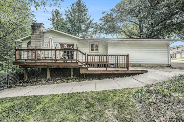 4649 Northview Ave NE, Grand Rapids, MI 49525 - back of house with a wooden deck, a chimney, and a lawn