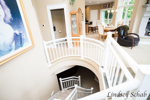 13025 Shaner Ave NE, Cedar Springs, MI 49319 - stairway featuring a chandelier, carpet, and a fireplace