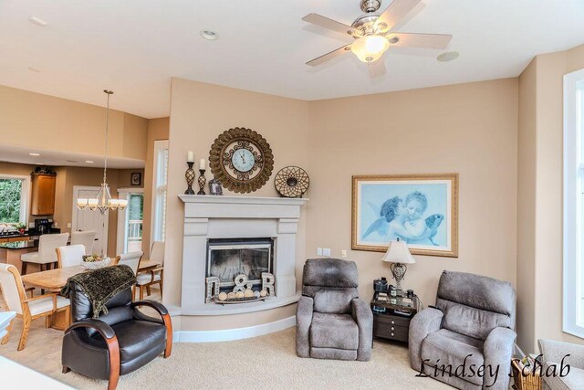13025 Shaner Ave NE, Cedar Springs, MI 49319 - living room with carpet floors, a ceiling fan, a glass covered fireplace, and a chandelier