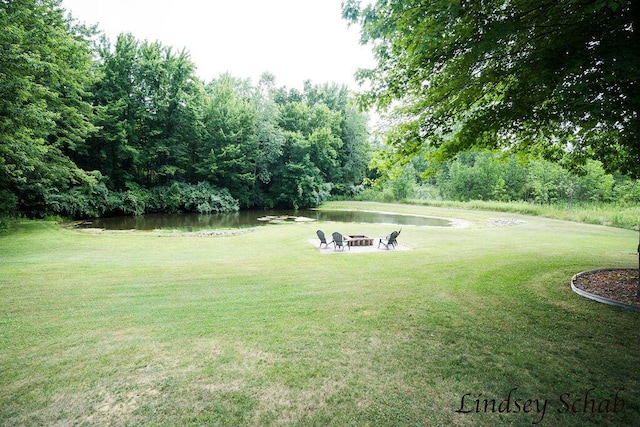 13025 Shaner Ave NE, Cedar Springs, MI 49319 - view of green lawn featuring an outdoor fire pit and a water view