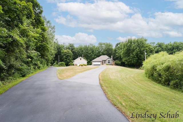 13025 Shaner Ave NE, Cedar Springs, MI 49319 - view of front of house featuring a front lawn, a garage, and a view of trees