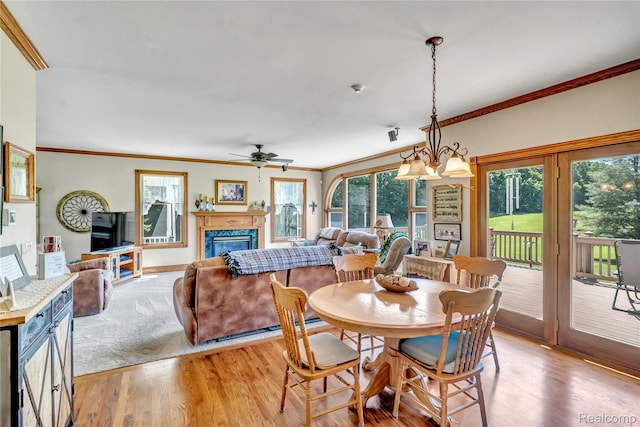 6728 Bowers Rd, Imlay City, MI 48444 - dining room featuring light wood-style flooring, crown molding, ceiling fan, and a glass covered fireplace