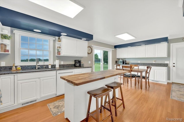 1647 Higley Rd, Lapeer, MI 48446 - kitchen with open shelves, wooden counters, white dishwasher, light wood-style flooring, and stainless steel microwave