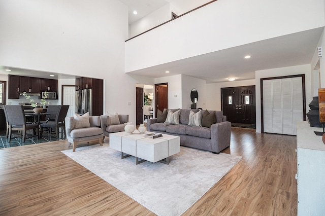 8411 Reese Ln, Ann Arbor, MI 48103 - living area featuring light wood-style flooring and a towering ceiling