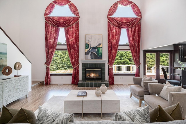 8411 Reese Ln, Ann Arbor, MI 48103 - living area with wood finished floors, a towering ceiling, a tiled fireplace, and french doors