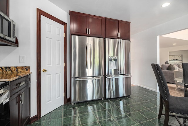 8411 Reese Ln, Ann Arbor, MI 48103 - kitchen featuring appliances with stainless steel finishes, dark stone counters, recessed lighting, and reddish brown cabinets