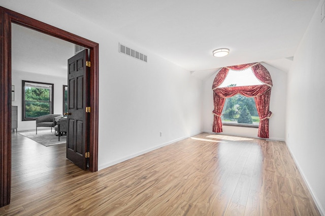 8411 Reese Ln, Ann Arbor, MI 48103 - empty room featuring plenty of natural light, wood finished floors, and lofted ceiling