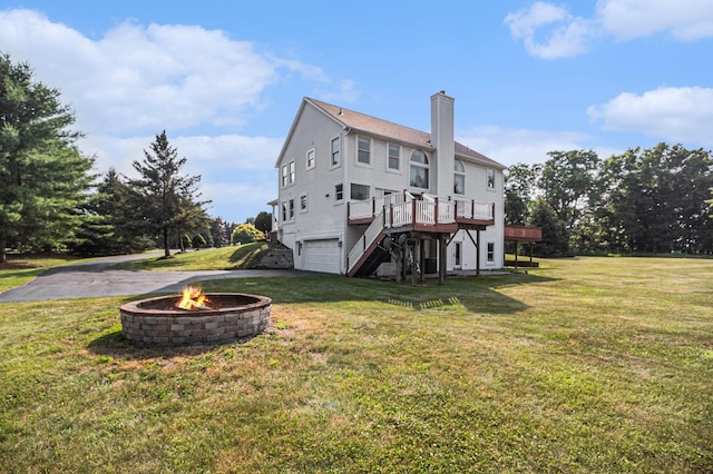 8411 Reese Ln, Ann Arbor, MI 48103 - rear view of house featuring a chimney, a garage, an outdoor fire pit, asphalt driveway, and a deck