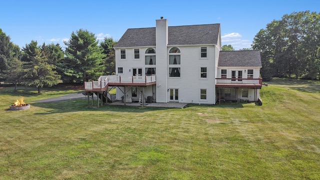 8411 Reese Ln, Ann Arbor, MI 48103 - back of house featuring a fire pit, a wooden deck, and a yard