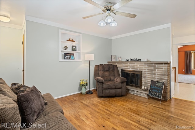 4391 Ashlawn Dr, Flint, MI 48507 - living area featuring built in features, wood finished floors, a brick fireplace, and a ceiling fan