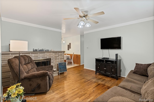 4391 Ashlawn Dr, Flint, MI 48507 - living room featuring wood finished floors, ceiling fan, a fireplace, and ornamental molding
