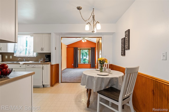 4391 Ashlawn Dr, Flint, MI 48507 - dining space featuring a wainscoted wall, ceiling fan, wood walls, and vaulted ceiling