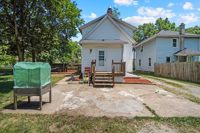 210 S Forbes St, Jackson, MI 49203 - rear view of house featuring a fenced backyard, a patio, a wooden deck, and a chimney