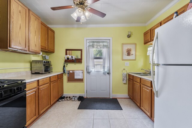 210 S Forbes St, Jackson, MI 49203 - kitchen with freestanding refrigerator, black range with gas stovetop, light countertops, a ceiling fan, and brown cabinets