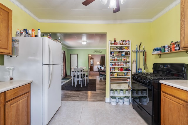 210 S Forbes St, Jackson, MI 49203 - kitchen featuring black gas stove, freestanding refrigerator, ornamental molding, ceiling fan, and light countertops